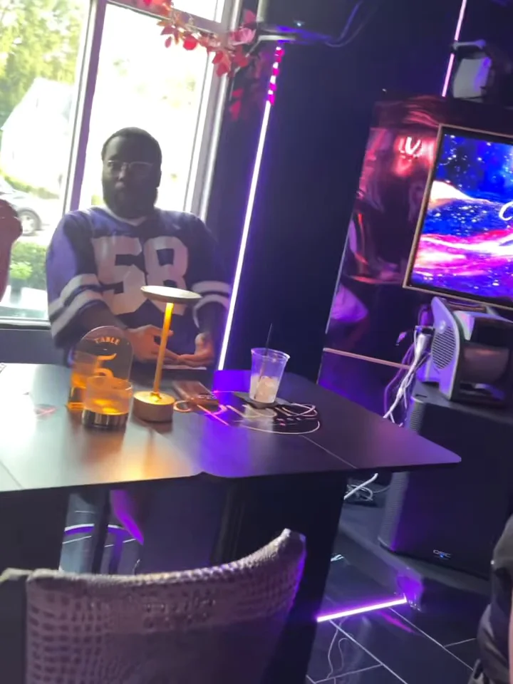 Guest in a football jersey at a window table at Pluto Lounge