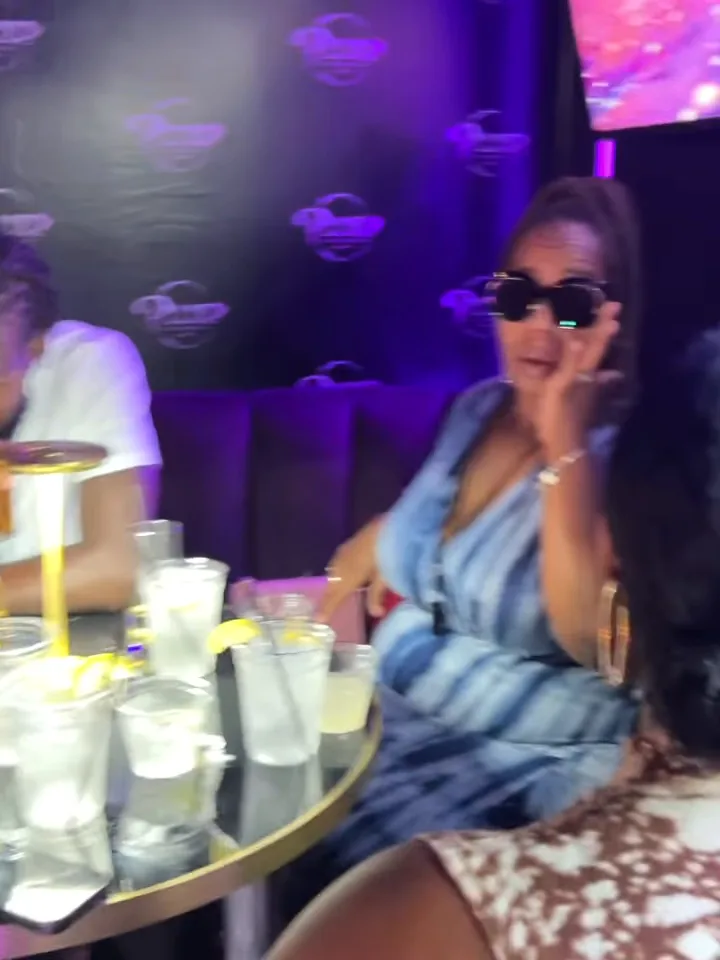 Guest in sunglasses at a Pluto Lounge table with drinks