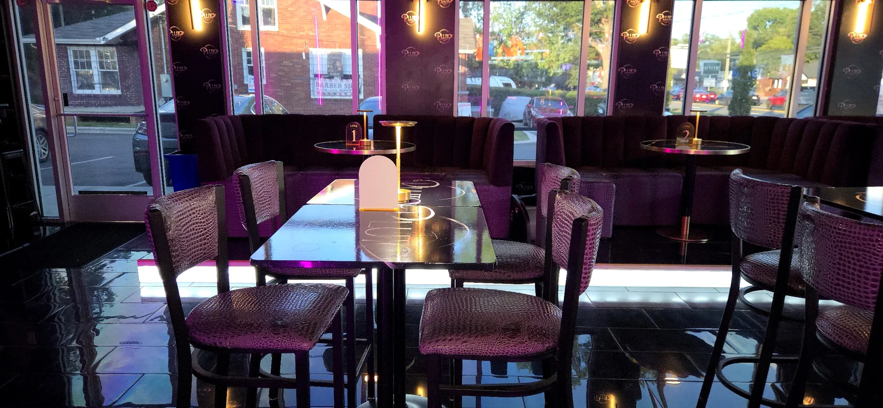Booths and high-tops by the windows at Pluto Lounge